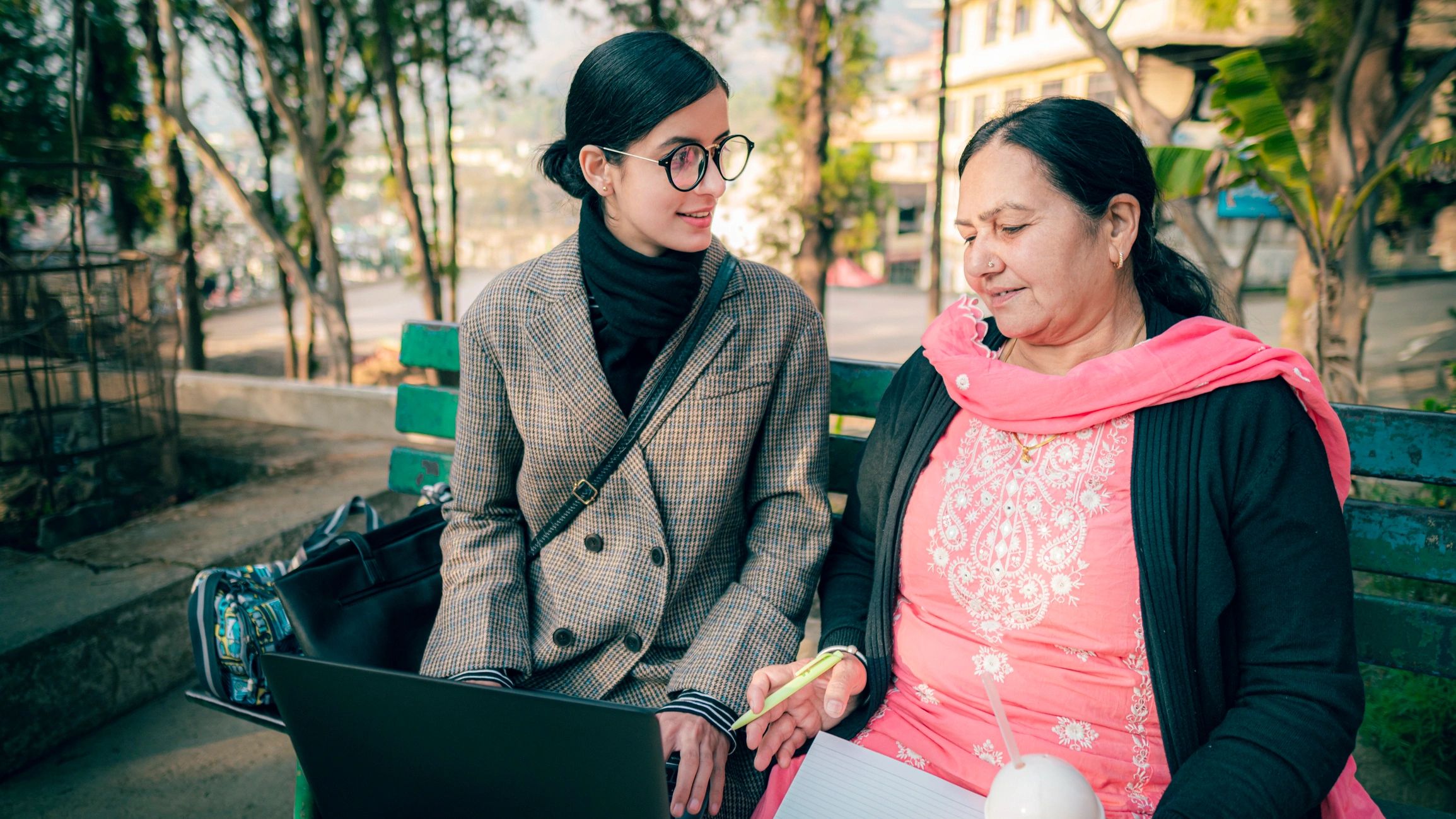 Mentor guiding a learner with a laptop and notebook