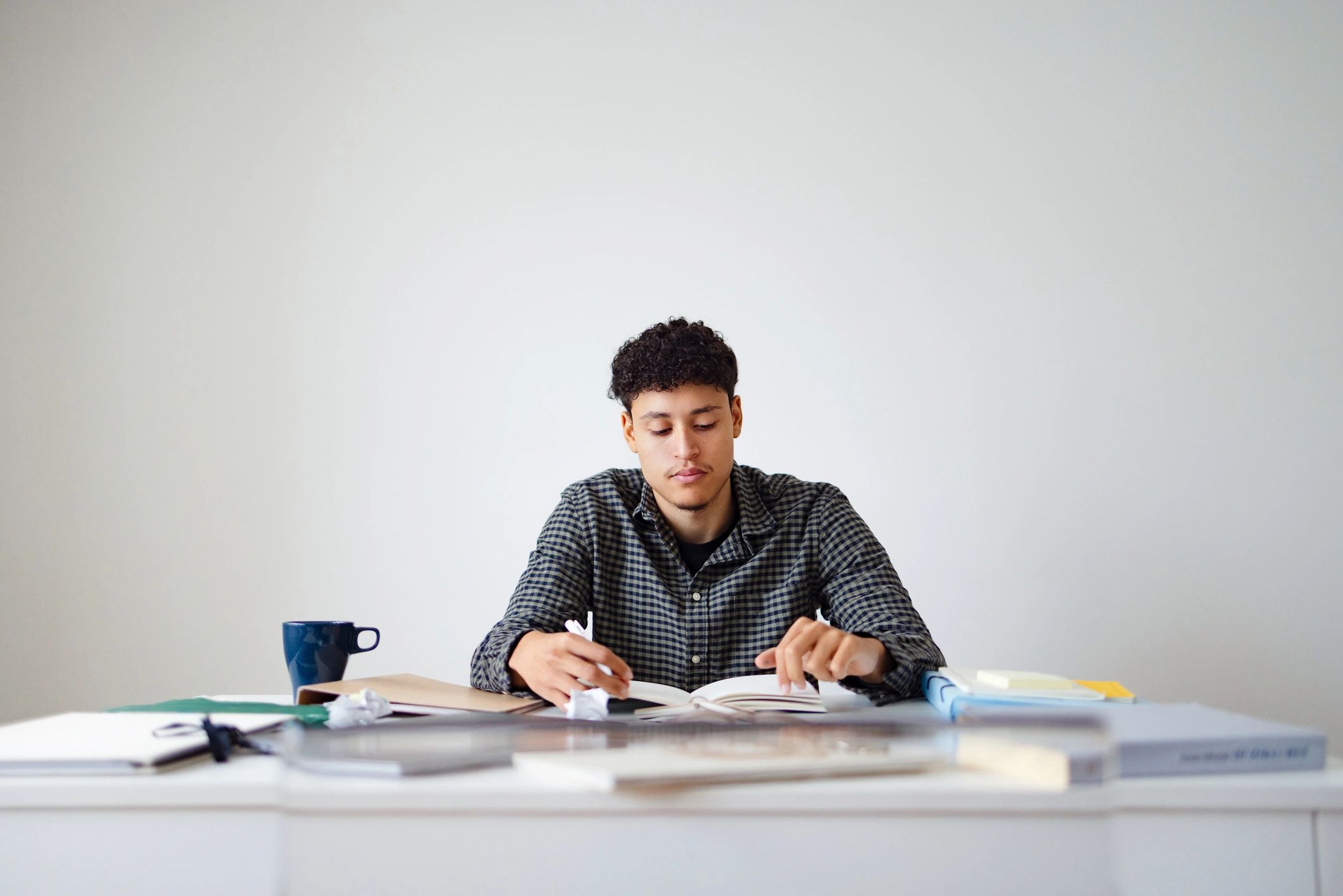 Student studying at a desk with books